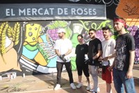 Set joves dibuixen un graffiti al Mercat Municipal de Roses per a commemorar el seu 35è aniversari